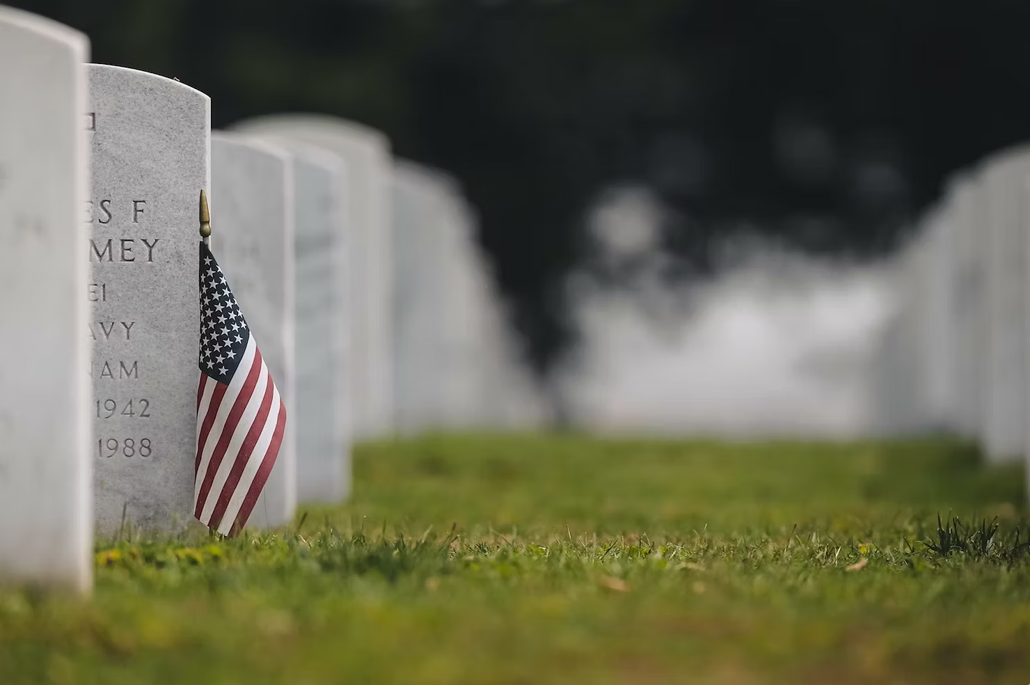 Stock photo of cemetery tombstones with American flag