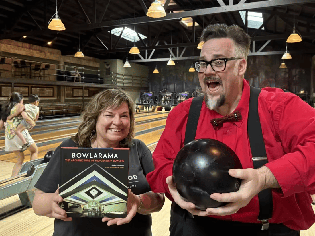 Photo of event speaker Chris Nichols at bowling alley next to woman holding Bowlarama book